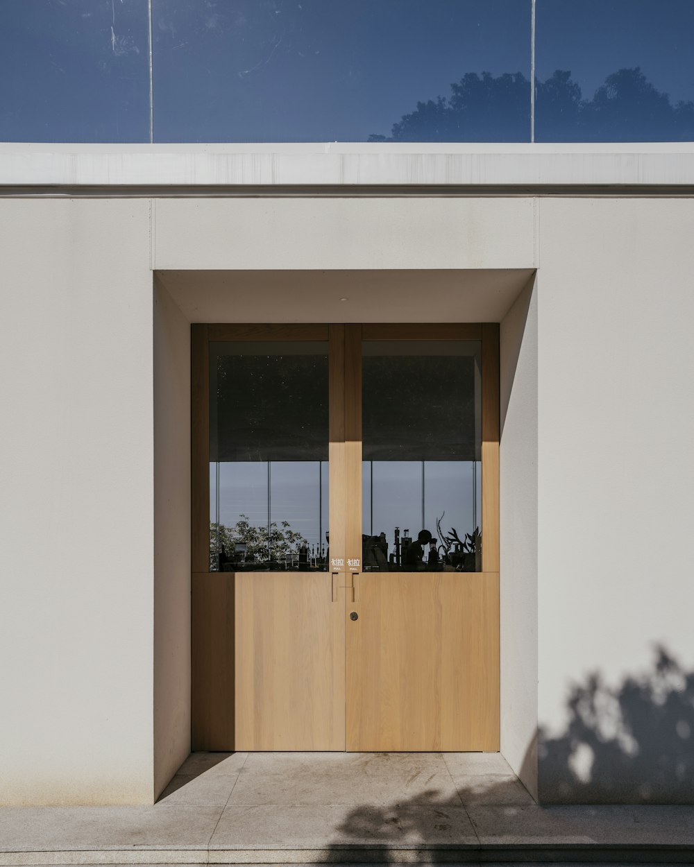 Fachada da clínica, com portas de madeira clara e parede clara